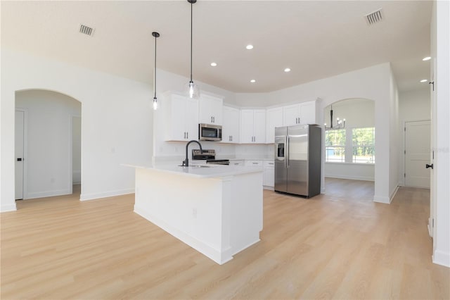 kitchen with appliances with stainless steel finishes, arched walkways, and visible vents