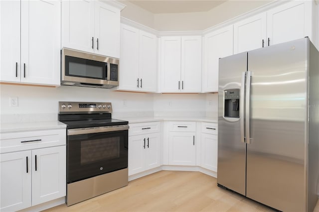 kitchen featuring stainless steel appliances, light wood-type flooring, light countertops, and white cabinets