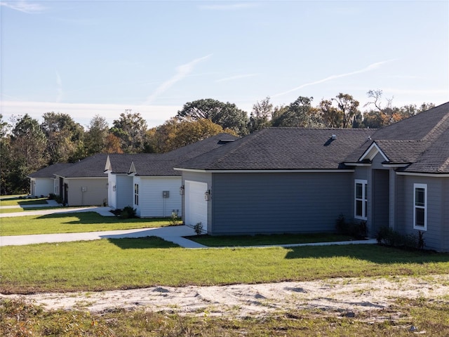 ranch-style house featuring a garage and a front lawn