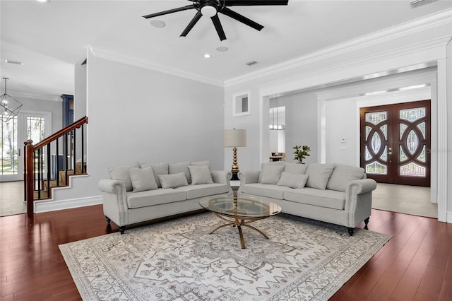 living room with dark wood-style floors, french doors, stairway, and crown molding