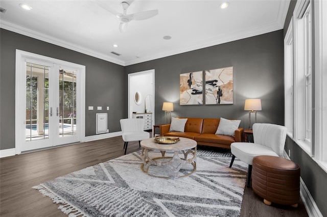 living area with visible vents, wood finished floors, and ornamental molding