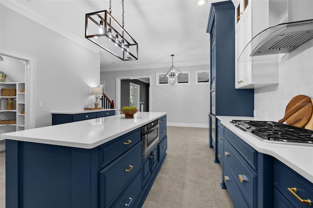 kitchen featuring blue cabinetry, light countertops, and wall chimney range hood