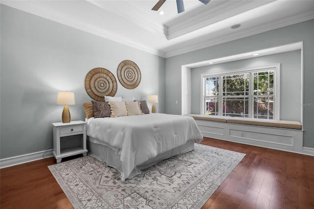 bedroom featuring ornamental molding, a raised ceiling, hardwood / wood-style flooring, and baseboards