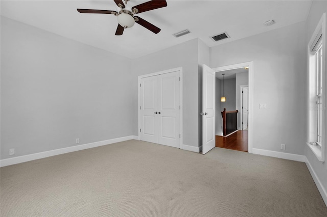 unfurnished bedroom featuring a closet, carpet flooring, visible vents, and baseboards