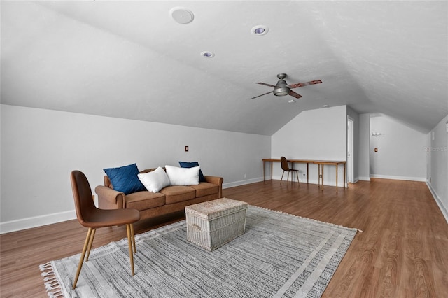 living area with lofted ceiling, baseboards, and wood finished floors