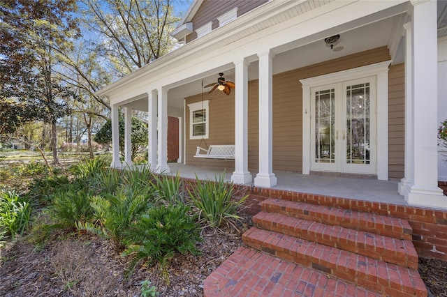 view of exterior entry featuring french doors and a porch