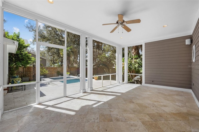 unfurnished sunroom featuring ceiling fan