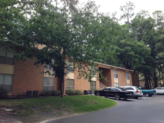 view of building exterior with uncovered parking