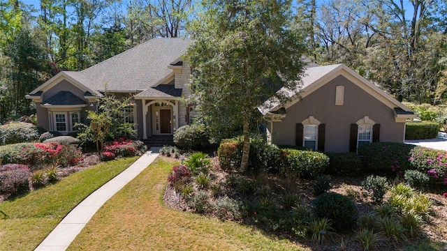 view of front of property with stucco siding and a front lawn