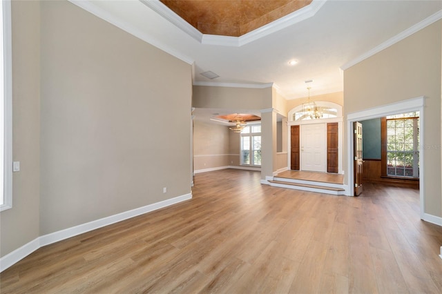 interior space with crown molding, a notable chandelier, baseboards, and light wood finished floors