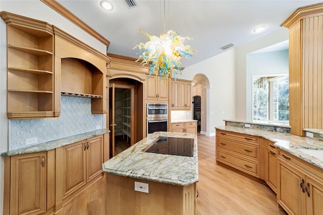 kitchen with visible vents, a center island, stainless steel double oven, arched walkways, and black electric stovetop