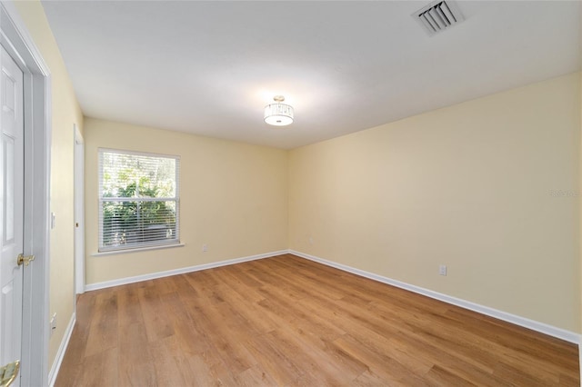 empty room with visible vents, baseboards, and light wood-style floors