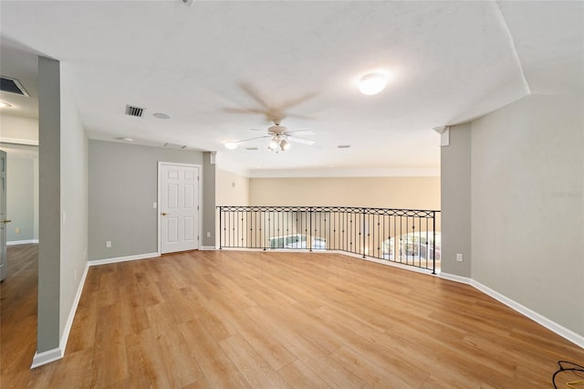 unfurnished room with light wood-type flooring, visible vents, baseboards, and ceiling fan