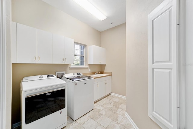 laundry room with washer and dryer, cabinet space, baseboards, and a sink