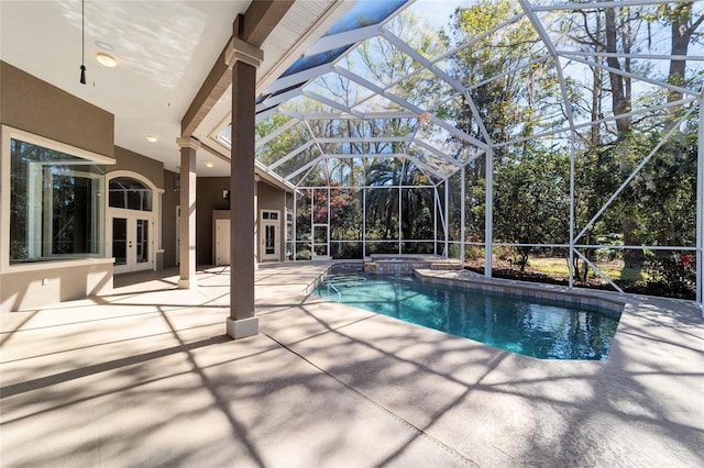 view of pool with glass enclosure, a patio, french doors, and a pool with connected hot tub