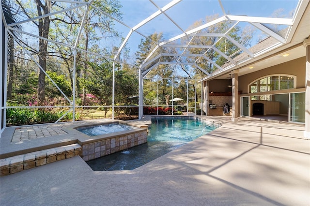 pool featuring glass enclosure, an in ground hot tub, and a patio