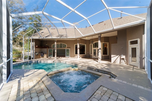 view of pool featuring glass enclosure, a patio area, and a pool with connected hot tub