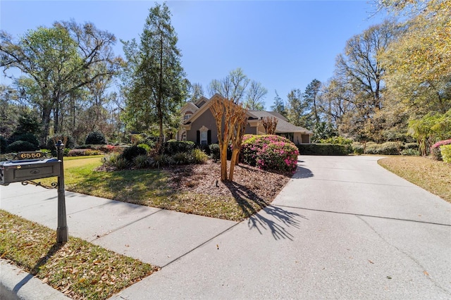 exterior space with concrete driveway and a front lawn