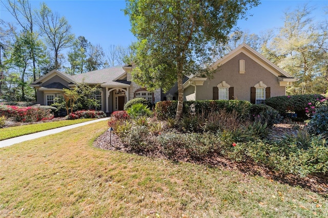 view of front of house with stucco siding and a front lawn