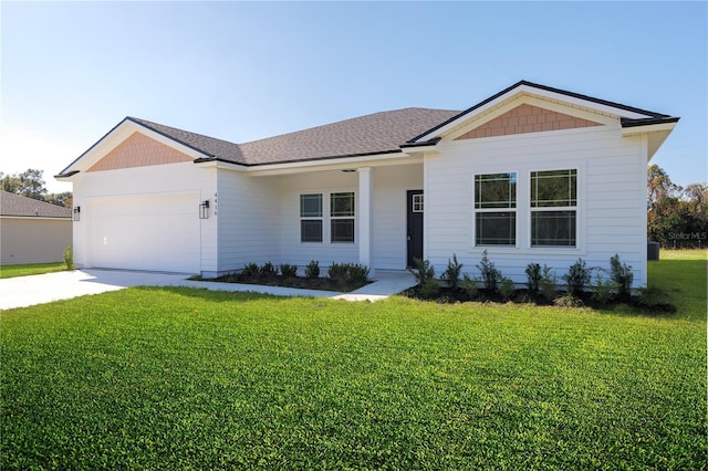 view of front of property with a garage, concrete driveway, a shingled roof, and a front yard