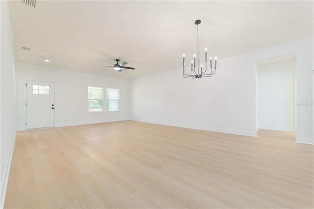 unfurnished room featuring visible vents, ceiling fan with notable chandelier, light wood-style flooring, and baseboards