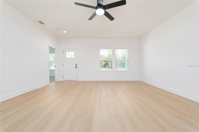 unfurnished living room with light wood-style floors, visible vents, baseboards, and a ceiling fan