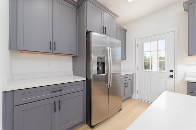 kitchen with light countertops, stainless steel fridge, and gray cabinetry