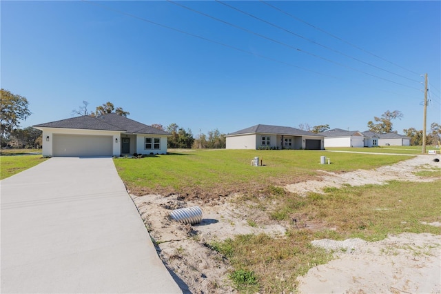 view of front of house featuring an attached garage, driveway, and a front yard