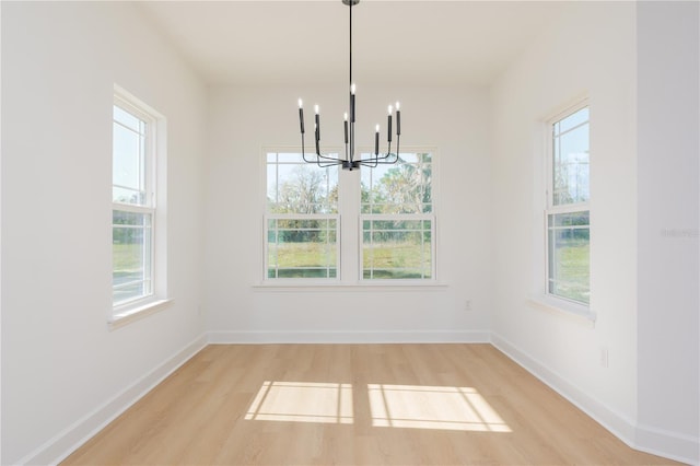 unfurnished dining area featuring baseboards, light wood-style flooring, and a healthy amount of sunlight