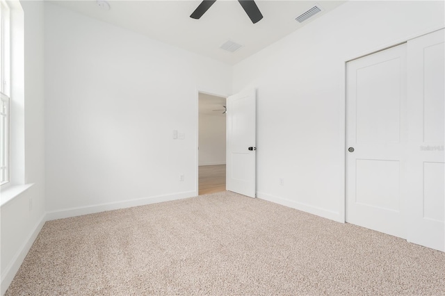 unfurnished bedroom with a closet, visible vents, a ceiling fan, carpet flooring, and baseboards