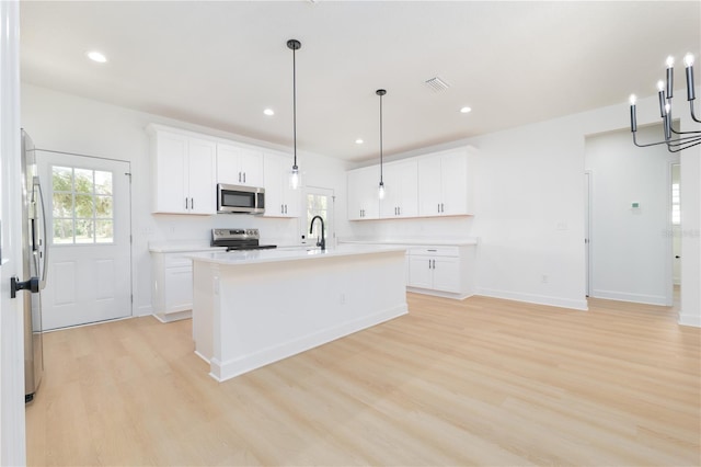 kitchen featuring stainless steel appliances, a wealth of natural light, light countertops, and light wood-style flooring