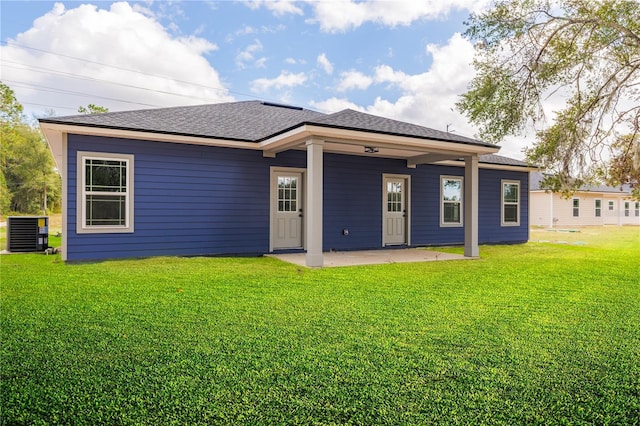 rear view of house featuring a yard, a shingled roof, a patio area, and central air condition unit