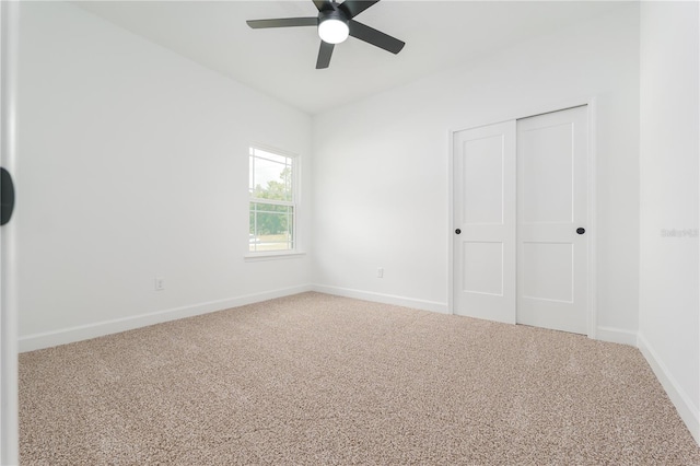 unfurnished bedroom featuring ceiling fan, a closet, carpet flooring, and baseboards