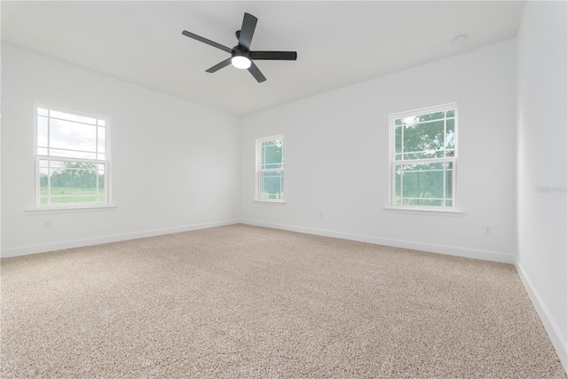 unfurnished room featuring baseboards, ceiling fan, and light colored carpet