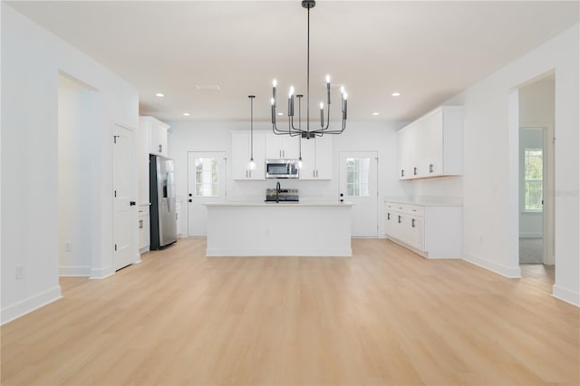 kitchen featuring light countertops, appliances with stainless steel finishes, light wood-style flooring, and white cabinets