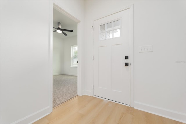 entryway featuring a ceiling fan, baseboards, and light wood finished floors