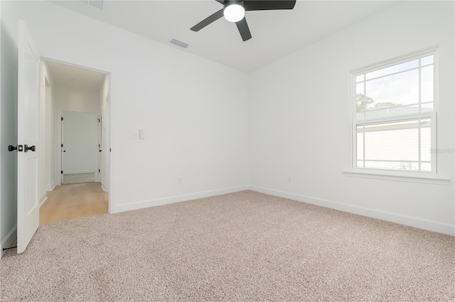 unfurnished room with baseboards, visible vents, a ceiling fan, and light colored carpet