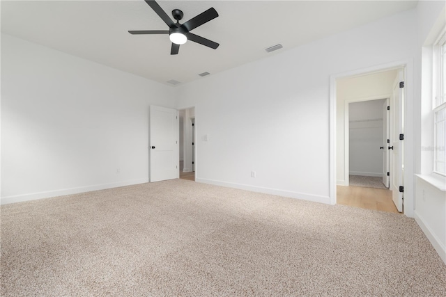 unfurnished room with light colored carpet, visible vents, and baseboards