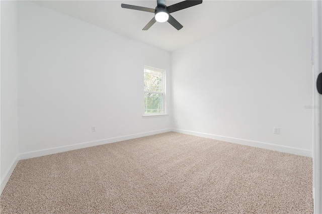 carpeted empty room featuring a ceiling fan and baseboards