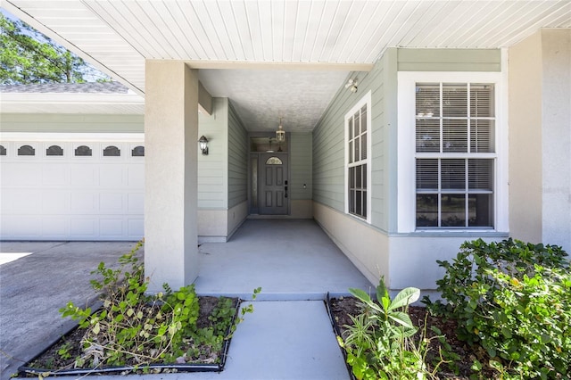 entrance to property with an attached garage and stucco siding