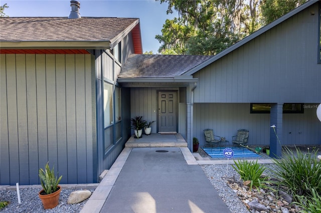 property entrance featuring a shingled roof