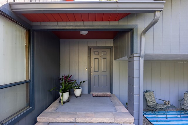 view of exterior entry featuring covered porch