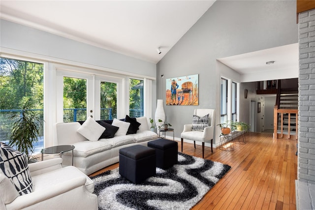 living room with high vaulted ceiling, french doors, and hardwood / wood-style floors