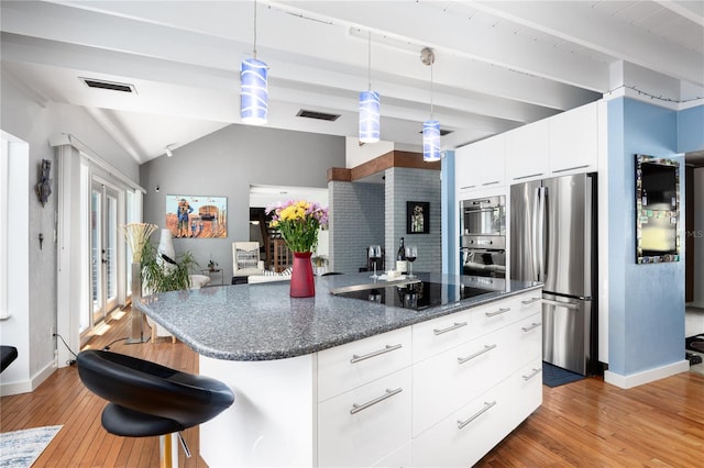 kitchen featuring light wood finished floors, visible vents, modern cabinets, stainless steel appliances, and pendant lighting