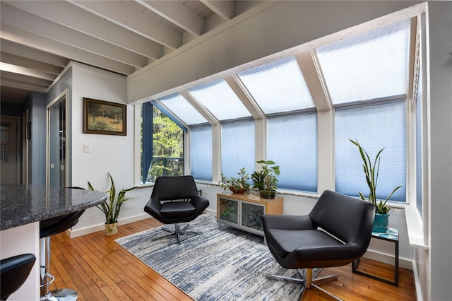 sitting room featuring a sunroom, baseboards, and hardwood / wood-style floors