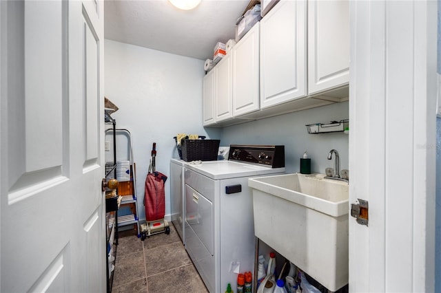 clothes washing area with cabinet space, a sink, and washer and clothes dryer