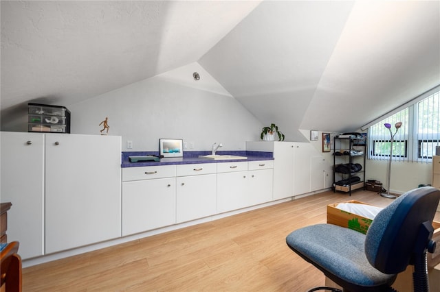 sitting room with vaulted ceiling and light wood-style flooring