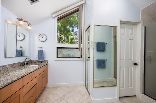 bathroom with lofted ceiling, a shower stall, visible vents, and vanity