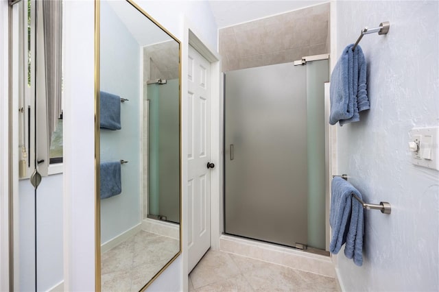 bathroom with tile patterned flooring and a shower stall