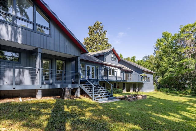 exterior space with a deck, stairway, and a lawn